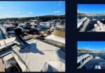 Marina full of luxury yachts docked on a sunny day; foreground shows a boat deck covered with white fabric.