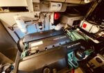 Volvo Penta D6-IPS 800 marine diesel engine in a boat’s engine room, with hoses, filters, and electrical components around it.