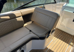 Cream leather boat seating with a honeycomb backrest pattern and teak deck, water visible outside the boat.