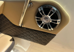 Beige boat interior panel with a round chrome Fusion speaker and brown quilted padding below.