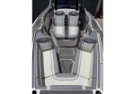 Top-down view of a luxury speedboat interior with six quilted light-gray and white seats, arranged around a central walkway, with a raised helm area at the stern and non-slip flooring.