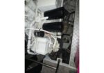 White industrial diesel engine with black cylindrical air filters and a network of white pipes and hoses.