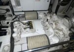 Large marine diesel generator set with dual air filters and white engine in a mechanical room.