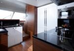 Modern yacht kitchen with white cabinets, black granite counters, and stainless steel appliances.