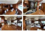 Interior of a luxury yacht with glossy wood paneling, oval dining table, and white chairs by large windows overlooking the water.