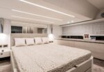 Modern luxury bedroom with a large bed, light headboard, and multiple pillows in a neutral palette.