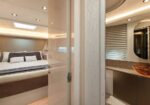 Luxurious yacht bedroom with a large bed and neutral décor, seen from the doorway into the ensuite bathroom.