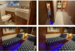 Small bathroom on a yacht with toilet and sink, wood cabinets and a porthole-style window above the sink.