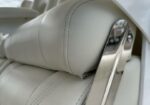 Close-up of a light gray leather headrest with a metal mounting bracket visible on the side.