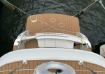 Top-down view of a tan teak boat deck with crisscrossing mooring lines, a life ring, and dark water surrounding the vessel; the boat name Grace is visible on the stern.