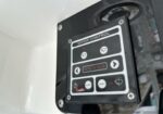 Close-up of a vehicle's wiper control panel mounted on the exterior, showing two wiper buttons, indicator lights, a wash button, and on/off switch labeled WIPER CONTROL.