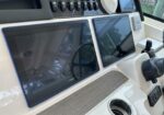 Dual Garmin marine displays mounted at the helm with surrounding control switches and a joystick nearby