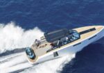 High-speed motorboat speeding across deep blue ocean with passengers on the deck and white wake behind it