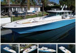 Large white and blue luxury motor yacht moored in a canal beside a waterfront home with palm trees in the yard.
