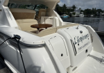 White luxury motor yacht docked at a marina with beige seating and a round wooden table on the rear deck; name L'Esperance, Fort Lauderdale, FL visible on stern.