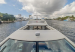 View from the bow of a white motorboat in a marina, with two Intellian radar domes and calm water.