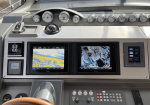 Boat cockpit dashboard with two Garmin navigation screens displaying map and camera view.