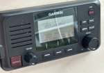Garmin marine GPS/chartplotter with screen and control buttons mounted on a boat dashboard