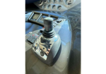 Joystick throttle control in a boat cockpit mounted on a chrome base, with gauges visible on the dash behind it.