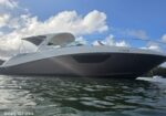 White sport yacht floating on calm water under a blue sky with clouds