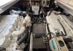 Twin diesel engines in a boat's engine room with hoses, belts, and mounting hardware visible on each side.