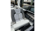 Boat cockpit seat with light gray cushions and two cupholders beside the console.