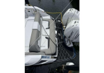 Rear view of a white motorboat tied to a dock; two Mercury outboard engines and a black swim‑platform mat.