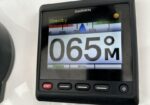 Garmin marine display showing 065° heading with standby indicator on a boat dashboard.