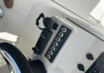 Cockpit radio and control panel with microphone hanging from the side and labeled knobs.