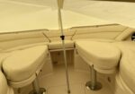 Cream leather boat cockpit seating with curved benches and a central support pole under a pale canopy/awning.