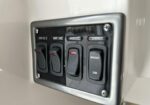 Panel with four rocker switches labeled Step Lts, Acnt Lts, Main Lts, and Dimmer for control of cabin lighting in a dim environment (metal plate).
