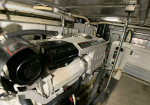 Marine diesel engine in an engine room, labeled Volvo Penta TAMD75ED, with hoses and pipes surrounding it.