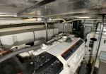 Engine room with a Volvo Penta diesel engine and surrounding marine equipment and hoses.