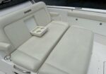 White boat seating with a built-in cup holder tray and an Everglades logo on the headrest.