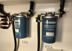 Two blue Yamaha marine fuel/water separating filters mounted side by side under a console, with hoses and clamps attached.