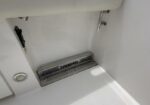 White boat deck area with a stainless steel foot tread labeled 'Everglades' near the seat cushion edge