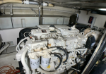 White diesel engine in a boat engine room, with fuel filters and a tangle of hoses and wires.