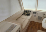 Cream leather bench seating along a boat cabin window with a black-and-white geometric pillow.