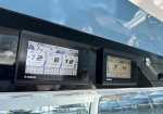 Two Yamaha boat engine gauges mounted at the helm, displaying RPM readouts and fuel/engine data against a blue sky reflection in the window.