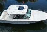 White Grady-White motorboat on dark water, with an American flag on a mast and three Yamaha outboard motors at the stern.