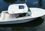 White motorboat on dark water, engines at rear, Grady-White name visible on hull, flag flying from top deck.