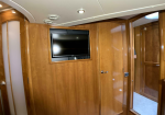 Wood-paneled cabin wall with a recessed flat-screen TV mounted in the center.