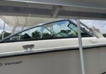 White motorboat under a boat lift with registration FL652IPY visible on the windshield and a white hull nearby.