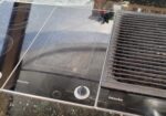 Miele glass induction cooktop with three cooking zones and control knobs, next to a grilling/vent area on the right.