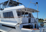White luxury yacht docked at a marina under a clear blue sky